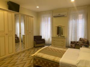 罗马可鲁西迪马耳他酒店的一间卧室配有一张床、一把椅子和镜子