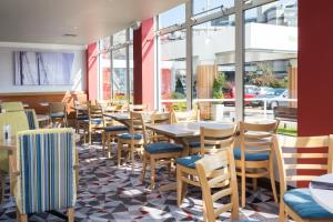南安普敦南安普敦假日酒店的餐厅设有桌椅和窗户。