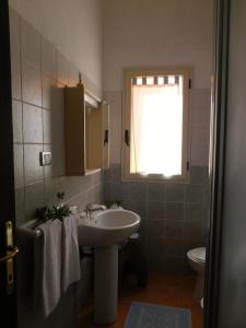 布多尼Residence La Pineta的一间带水槽和卫生间的浴室以及窗户。