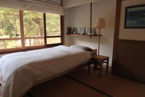 Kitsuki奈多みどり荘 Nada Beach House的一间卧室设有一张大床和一个窗户。