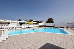 蒂亚斯Colina del Sol Lanzarote Pool with sea view的一座位于庭院的大型游泳池,庭院内有一座建筑