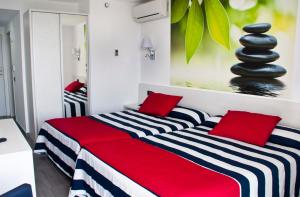 马尔格莱特德玛欧罗巴水上乐园及Spa酒店的一间卧室配有两张带红色和黑色枕头的床