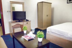 利雅德法尔汉酒店套房（15号出口）的客房设有一张床和一张桌子及电视