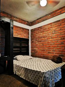 埃尔富埃尔特Posada Don Jose的一间带砖墙和两张床的卧室