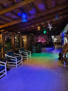 姆万扎Hotel Tilapia的一间设有椅子和紫色灯光舞台的房间