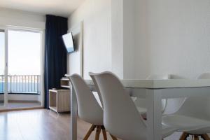 贝尼多姆Apartamentos La Mar的一间设有白色桌子和白色椅子的用餐室