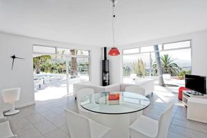 拉奥罗塔瓦Casa pequena的客厅配有玻璃桌和白色椅子