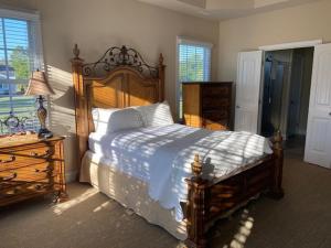 WallaceCottages and Suites at River Landing的一间卧室配有一张大型木床和一个梳妆台。