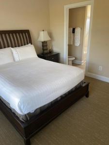 WallaceCottages and Suites at River Landing的一间卧室配有一张带白色床单和灯的大床