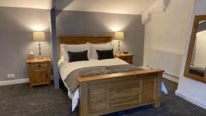 利兹桥农场酒店的一间卧室配有一张带2个床头柜和2盏灯的床。