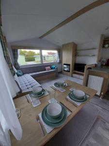 纳尔斯伯勒Woofles Luxury Caravan at Knaresborough Lido的客厅里一张带盘子的桌子