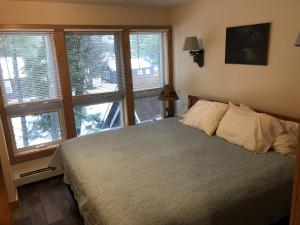 InletThe Woods Inn的一间卧室,配有一张床和一束窗户