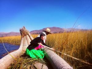 普诺Titicaca的女人坐在水中网的顶上