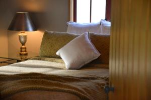 CartertonTerracotta Lodge & Cottages的卧室配有带枕头的床铺和窗户。