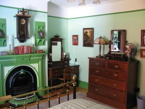 圣约翰斯Gower Manor Historic Bed & Breakfast的客房设有壁炉、梳妆台和镜子