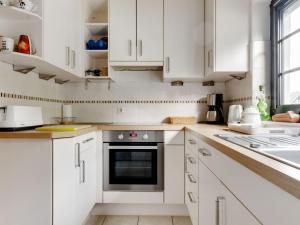 奥尔斯贝格Cosy holiday home in Olsberg with garden的白色的厨房配有白色橱柜和烤箱