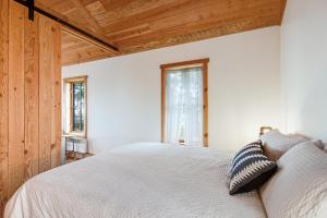 伊斯特海湾Little Refuge in town的卧室设有白色的床和木制天花板。