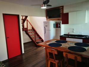 圣米格尔-杜斯米拉格里斯Zen Spa Houses的厨房配有木桌和红色的门