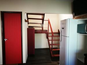 圣米格尔-杜斯米拉格里斯Zen Spa Houses的一间设有冰箱和红色门的房间