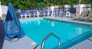 海泉市海洋温泉戴斯酒店的一个带蓝色椅子和遮阳伞的游泳池