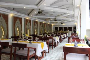 暹粒Khmer Mansion Residence的餐厅内带桌椅的用餐室