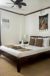 长滩岛爱丝拉壁虎岛度假酒店的一间卧室配有一张大床和吊扇