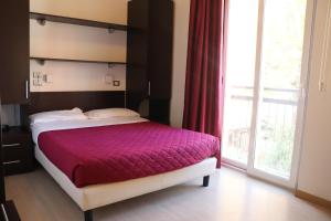 里米尼Hotel Morolli的一间卧室设有一张床和一个大窗户
