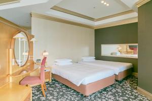 大阪大阪海鸥天保山酒店的一间卧室配有两张床、一张桌子和一把椅子