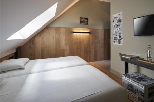 博尔赫隆Café Coureur Borgloon的一间带两张床和电视的卧室