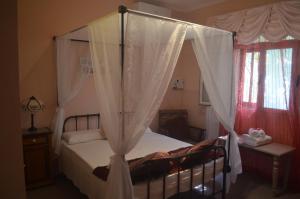Hal GhaxiakCasa Montegri的卧室配有带白色窗帘的天蓬床