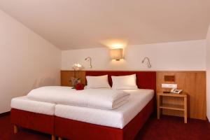 索尔登玛丽亚特蕾西娅咖瑞妮酒店的一间卧室配有一张大床和红色床头板