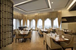 乌代浦华美达乌代布尔度假酒店的用餐室设有桌椅和窗户。