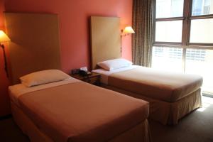 新加坡Classique Hotel的酒店客房设有两张床和窗户。