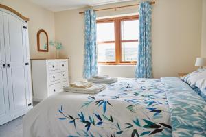 EdlinghamFinest Retreats - Quail's Nest Cottage的一间卧室配有一张蓝色窗帘的床