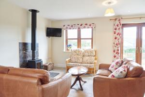 EdlinghamFinest Retreats - Quail's Nest Cottage的客厅设有两张沙发和一个壁炉