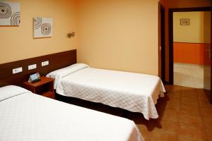 布尔戈斯Alojamiento Numancia Pensión的一间酒店客房内设有两张床的房间