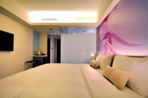 桃园市欧帝花园商务旅馆的一间卧室配有一张大床和紫色墙壁