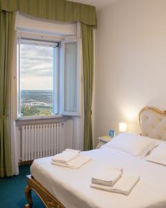 贝尔蒂诺罗全景酒店的一间卧室设有一张大床和大窗户