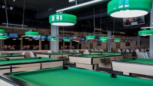 GrensThe Bowling Hotel的一个带绿色桌子和显示器的台球室