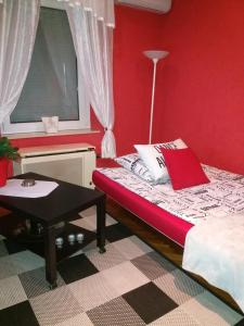 布达佩斯吉泽拉一室公寓酒店的红色的房间,配有床和桌子