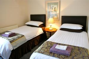 道格拉斯梅尔罗斯旅馆的客房设有两张床和一张带台灯的桌子。