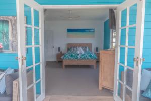 MyolaThe Jetty House Jervis Bay的一间卧室设有一张床和蓝色的墙壁