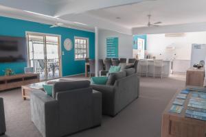 MyolaThe Jetty House Jervis Bay的一间带蓝色墙壁和沙发的客厅以及一间厨房