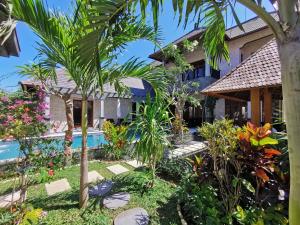 努沙杜瓦Artoria Dream Villas Bali的一座带花园和游泳池的房子