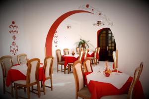 索瓦塔Hotel Tivoli的一间设有红色和白色桌椅的用餐室