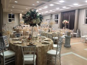 奥玛鲁Teschemakers Resort的宴会厅配有桌椅和鲜花