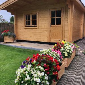 MarkinchCosy Log Cabin - The Dookit - Fife的木制棚屋前的花园