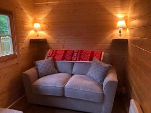 MarkinchCosy Log Cabin - The Dookit - Fife的一张沙发,位于带两盏灯的房间的角落
