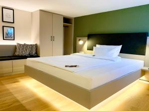 埃朗根兹沃赫豪斯u套房酒店&服务式公寓的一间卧室设有一张白色大床和绿色的墙壁