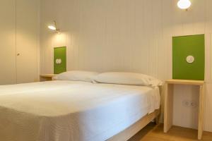 锡古恩萨Apartamento Alcuneza en Elmolinodelasal de Sigüenza的一间卧室配有一张带白色床单和绿色调的床。